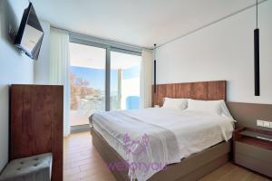 sypialnia z łóżkiem i przesuwanymi szklanymi drzwiami w obiekcie weforyou Sea Views Fuengirola 5 Wave w mieście Fuengirola