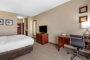 a hotel room with a bed and a desk with a computer at Comfort Inn & Suites St Louis-O'Fallon in O'Fallon