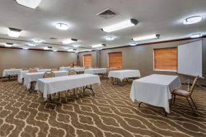 una sala de conferencias con mesas y una pizarra. en Comfort Inn & Suites St Louis-O'Fallon, en O'Fallon