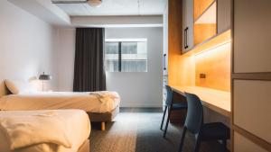 a hotel room with two beds and a desk and chairs at Apex2100 International Ski Academy Tignes in Tignes