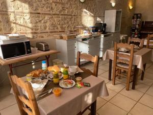 - une cuisine avec une table et de la nourriture dans l'établissement Relais des Iles chambres d'hôtes, à Agen