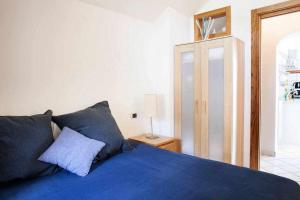 a bedroom with a bed with blue sheets and a lamp at Donna Saretta Casetta tradizionale Amalfitana in Amalfi