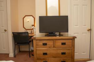 A television and/or entertainment centre at Ascot Grange Hotel - Voujon Resturant