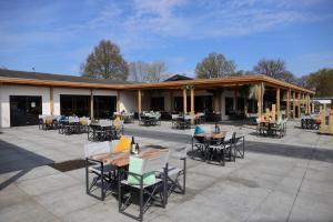 a patio with tables and chairs in front of a building at Recreatiepark de Boshoek in Voorthuizen