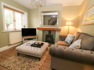 a living room with a couch and a table at 2 Sandringham Cottages in Brough