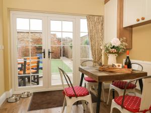 a kitchen with a table and chairs and a window at 2 Sandringham Cottages in Brough