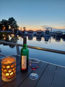 a bottle of wine and a glass on a table at Hausboot Leukermeer Well in Well