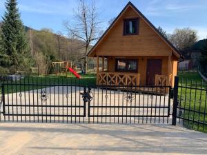 a fence in front of a house with a playground at „ Lawendowy zakątek”/„Lavender cottage” in Żywiec in Żywiec