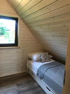 een bed in een blokhut met een raam bij „ Lawendowy zakątek”/„Lavender cottage” in Żywiec in Żywiec