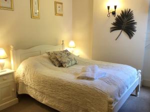 Un dormitorio con una cama blanca con una toalla. en The Priory, en Scorton