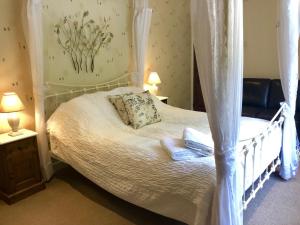 a bedroom with a canopy bed with towels on it at The Priory in Scorton