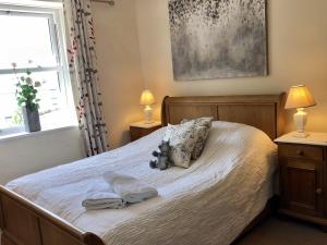 een slaapkamer met een bed met handdoeken en een teddybeer erop bij The Priory in Scorton