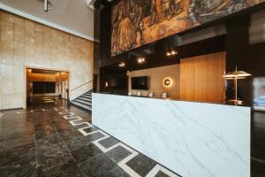 a lobby with a large marble counter in a building at Barceló León Conde Luna in León