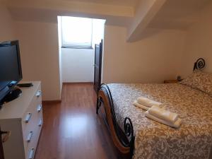 um quarto com uma cama com duas toalhas brancas em The Angy's Flat em Domodossola