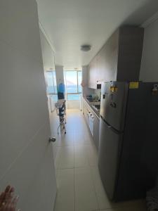 a kitchen with a refrigerator and a table in it at Departamento Vista Azul in Iquique