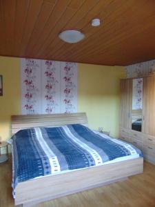 a bedroom with a bed with a blue comforter at Ferienwohnung Astor zwischen Rhein und Mosel in Plaidt