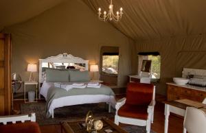 a bedroom with a bed and a chair in a tent at Oakron at Patatsfontein Stay in Montagu