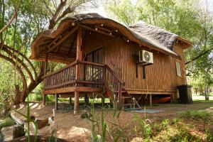 eine große Holzhütte mit einem Strohdach in der Unterkunft Oranjerus Resort in Kanoneiland