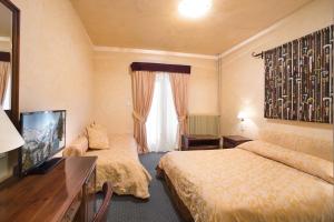 a hotel room with two beds and a television at Country Club Hotel & Suites in Mikro Chorio