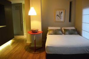 a small bedroom with a bed and a table at Hotel Living 55 in Bogotá