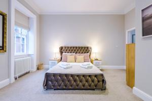 a large bedroom with a large bed with two lamps at Cromwell House in Chester
