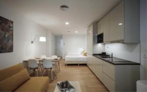 een keuken en een woonkamer met een bank en een tafel bij MUSH ROOM APARTAMENTOS in Sevilla
