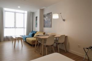 sala de estar con mesa y sofá en MUSH ROOM APARTAMENTOS en Sevilla