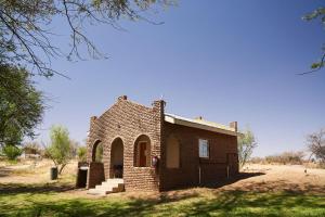 a small brick building in the middle of a field at Oranjerus Resort in Kanoneiland