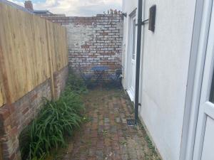an alley with a table and a brick wall at Lovely Coach House with Free Parking in Cardiff