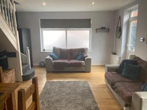 カーディフにあるLovely Coach House with Free Parkingのソファと椅子のあるリビングルーム
