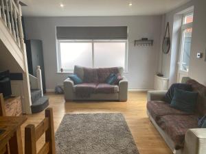 a living room with a couch and a chair at Lovely Coach House with Free Parking in Cardiff