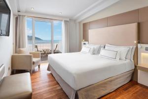 1 dormitorio con 1 cama blanca grande y balcón en Melia Maria Pita en A Coruña