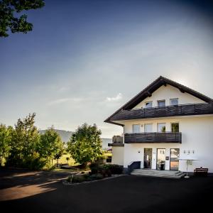 uma casa branca com um telhado preto em MUT.HAUS em Bischofsheim an der Rhön