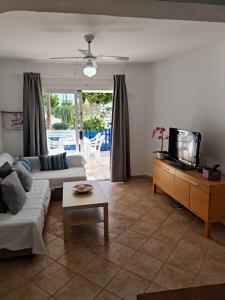 a living room with a couch and a tv at Avenue Puerto del Carmen in Puerto del Carmen