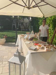 Uma mulher ao lado de uma mesa com comida. em Palma Salentina em Lizzano