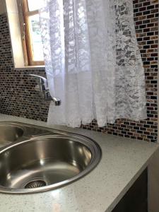fregadero de acero inoxidable en una cocina con ventana en Stonebass Lodge en Newlands