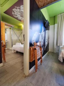 Cette chambre comprend un lit et un mur orné d'une fresque murale. dans l'établissement La Posada de El Chaflán, à Madrid