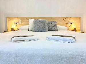 a bedroom with a large white bed with two lamps at Suite Apto de Invitados- Heated Pool-Piscina Climatizada- Montes de Málaga in Málaga