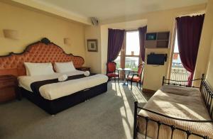 a bedroom with a large bed and a large window at New Madeira Seafront Hotel in Brighton & Hove