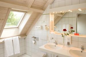 a white bathroom with a sink and a mirror at Globales Conti in Dietikon
