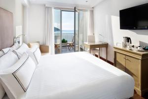 a bedroom with a large white bed with a view of the ocean at Melia Maria Pita in A Coruña
