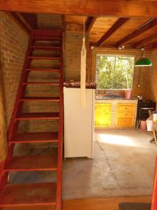 a kitchen with a ladder and a refrigerator in a room at Cabana na Floresta Rincão do Fortaleza in Cambara do Sul