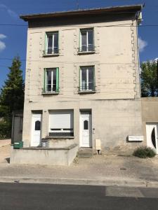 a white building with white doors and windows at Appartement Cosy à quelques minutes du Centre in Chalons en Champagne