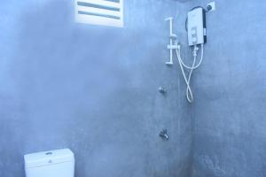 a bathroom with a toilet and a phone on the wall at The Ivory in Udawalawe +24 photos