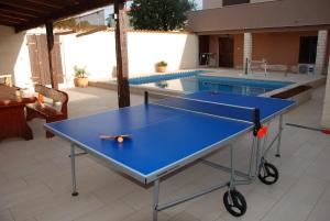 a blue ping pong table in front of a swimming pool at Holiday House Eleonora in Barban