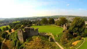 Kasbah cosy cottage Kendal في كندال: قلعة قديمة على تلة مع حقل أخضر