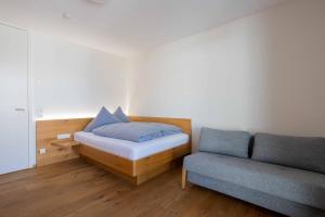 a small bedroom with a bed and a couch at Krone Apartments Top 6 / Top 7 / Top 8 in Schruns