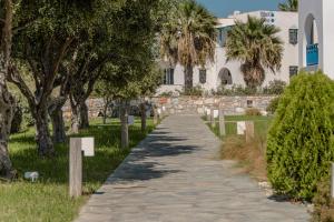 a walking path in front of a white building at Alykes Studios & Suites in Agios Prokopios