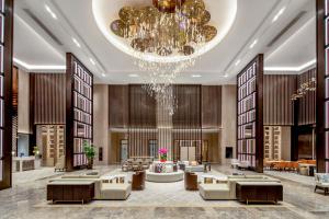 a lobby of a hotel with a chandelier at Pullman Suzhou Taicang in Taicang