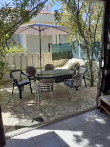 a patio with a table and chairs and an umbrella at Josip 1 Gajac in Novalja